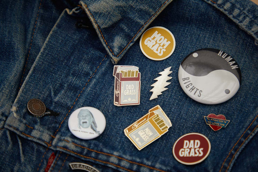Mom Grass Circle Pin with other pins on a denim jacket